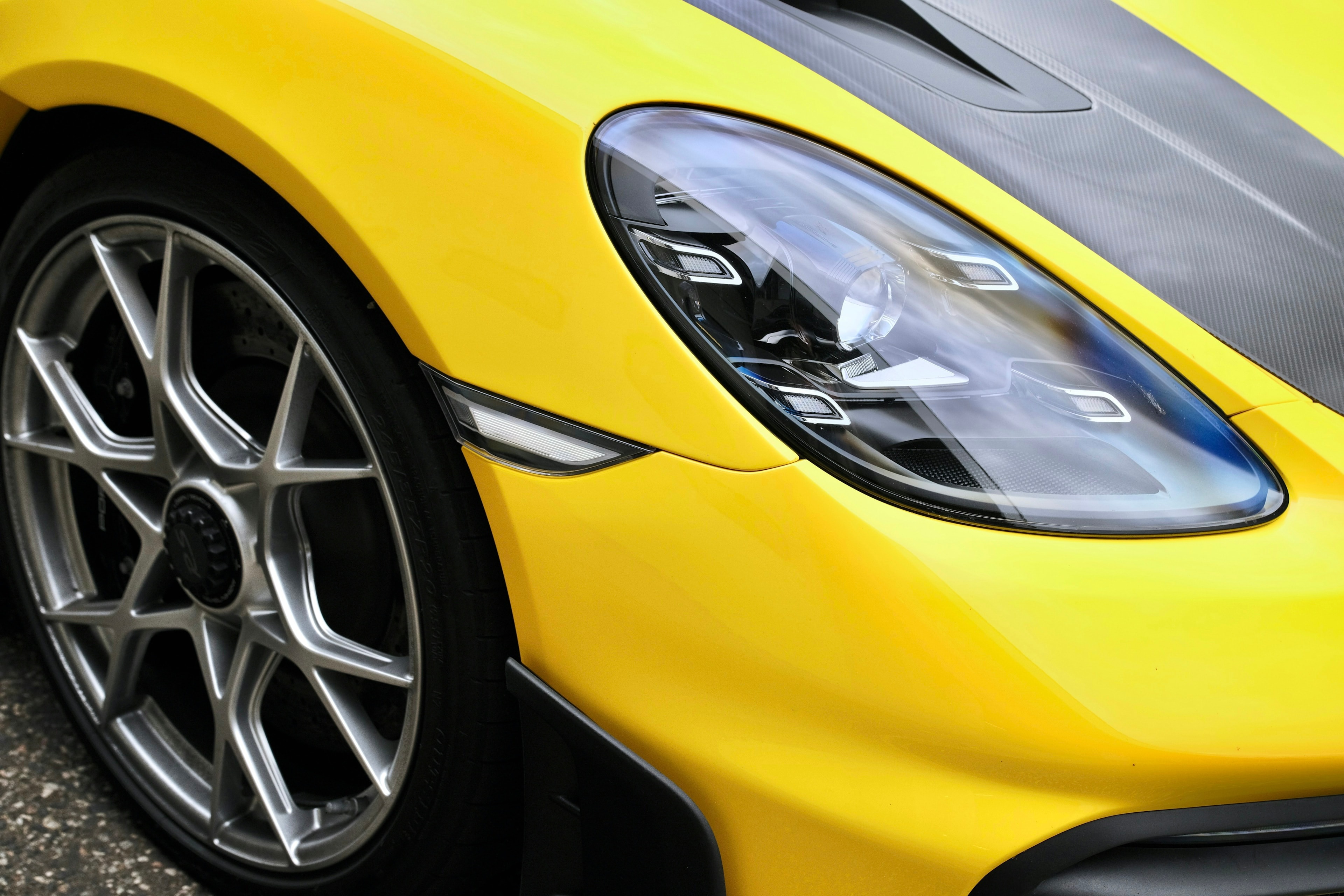 Yellow Porsche headlight and wheel: About Us, Blue Chip Auto Glass