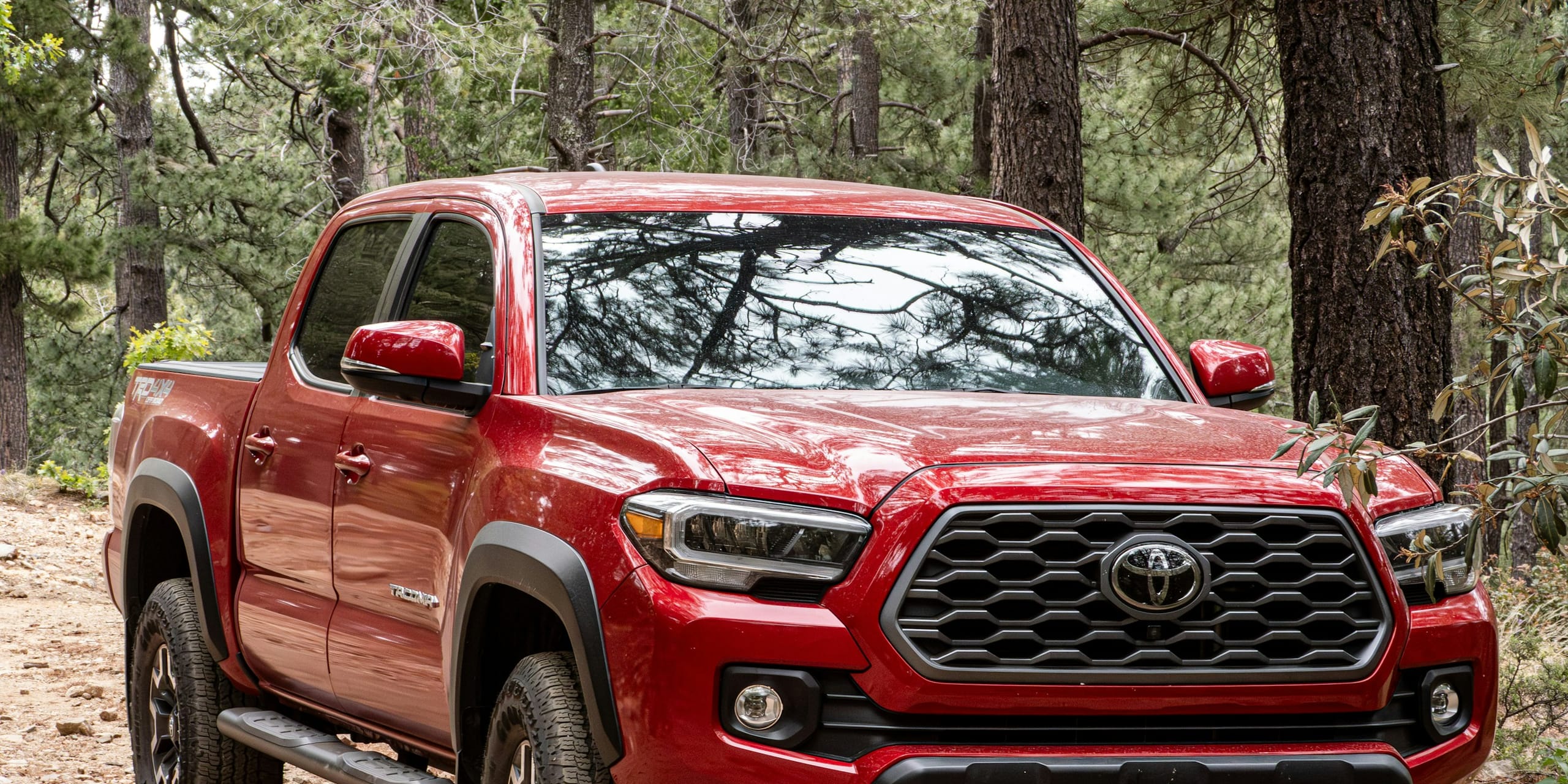 Red Toyota Tacoma on a dirt road: Insurance or out of pocket, how does it work?, Blue Chip Auto Glass