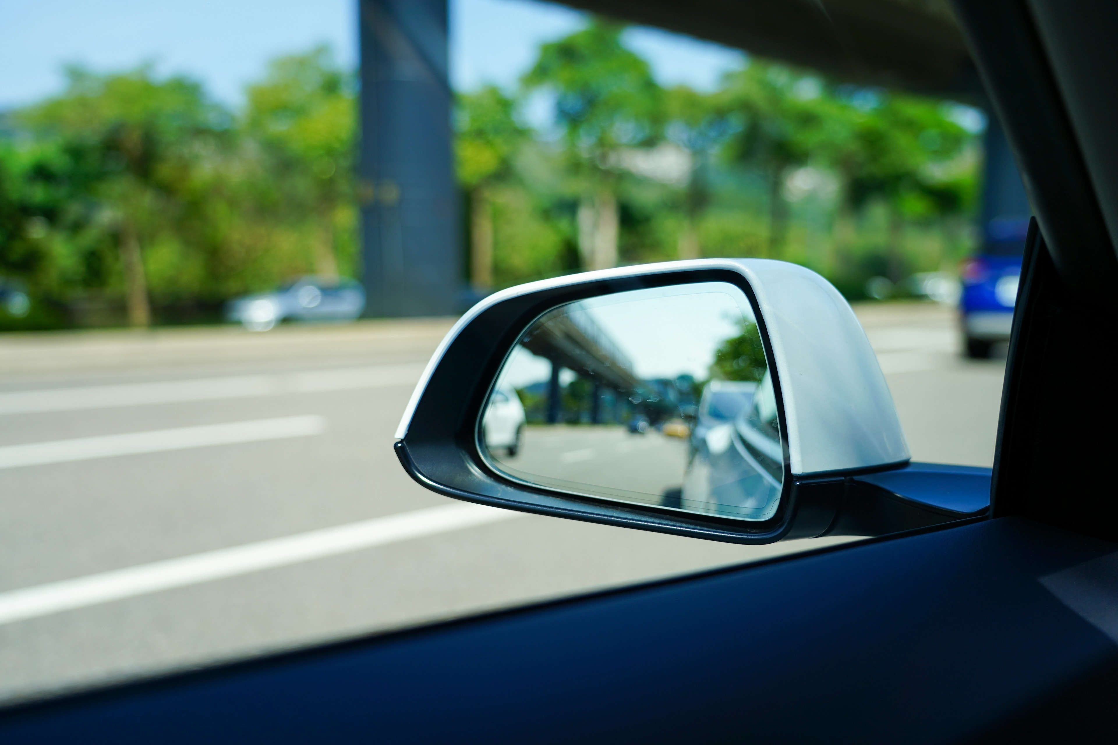 Silver side mirror on a sunny road: Mobile Windshield Replacement, Blue Chip Auto Glass