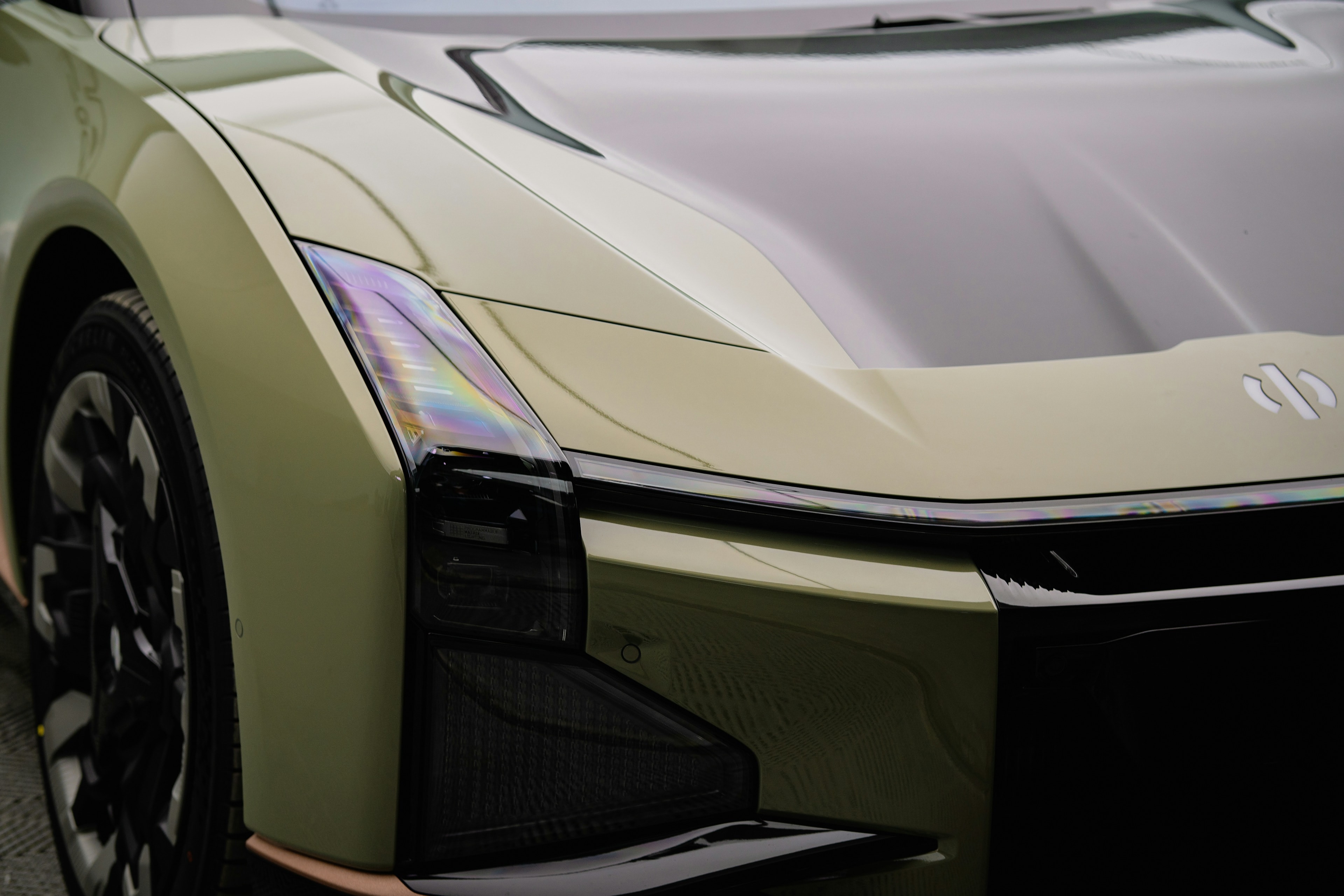 Modern EV front detail, soft light: Professionally Trained Technicians, Blue Chip Auto Glass