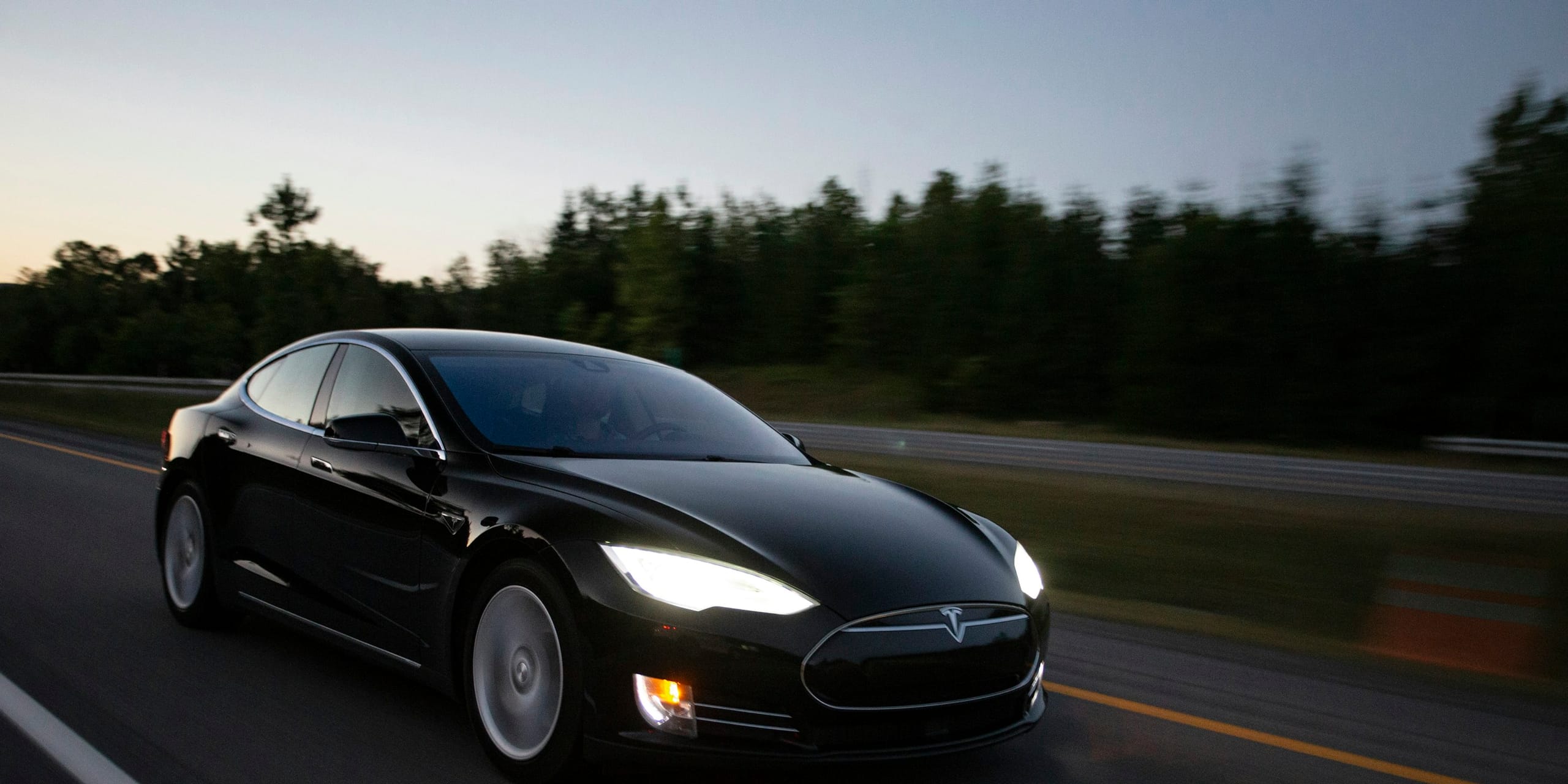Black Tesla Model S driving at dusk: Tesla Model S Windshield & Glass Replacement, Blue Chip Auto Glass