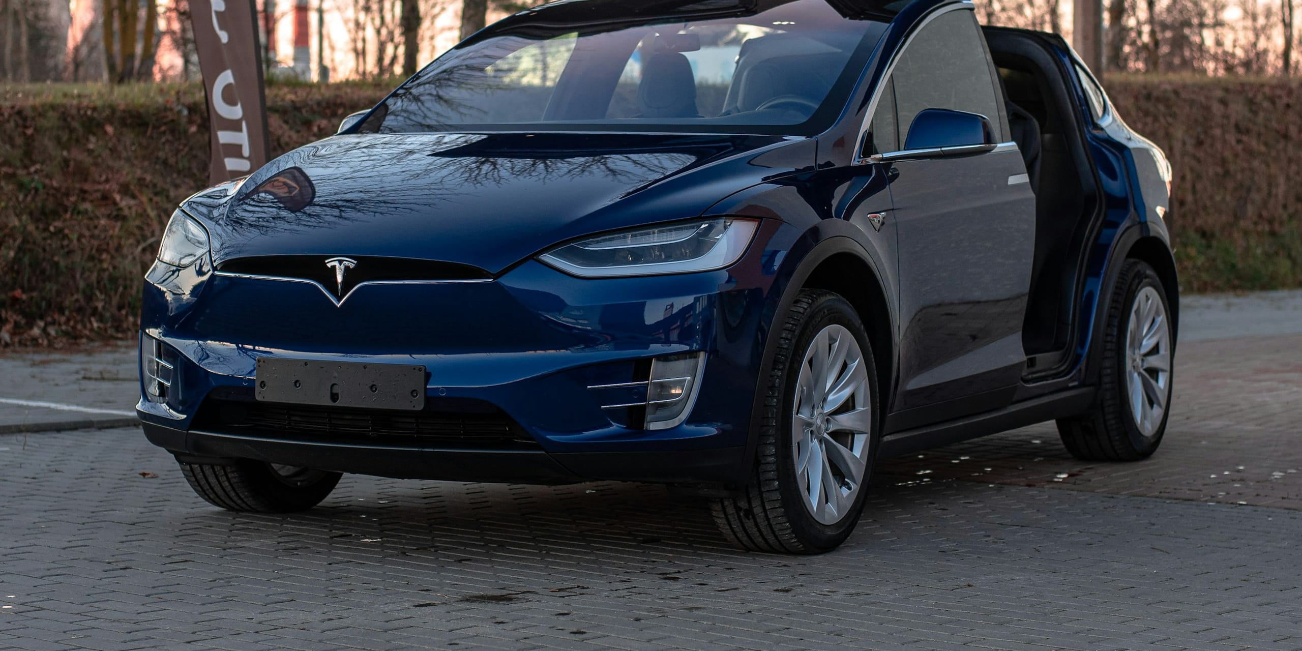 Blue Tesla Model X with its Falcon Wing doors open: Tesla Model X Windshield & Glass Replacement, Blue Chip Auto Glass