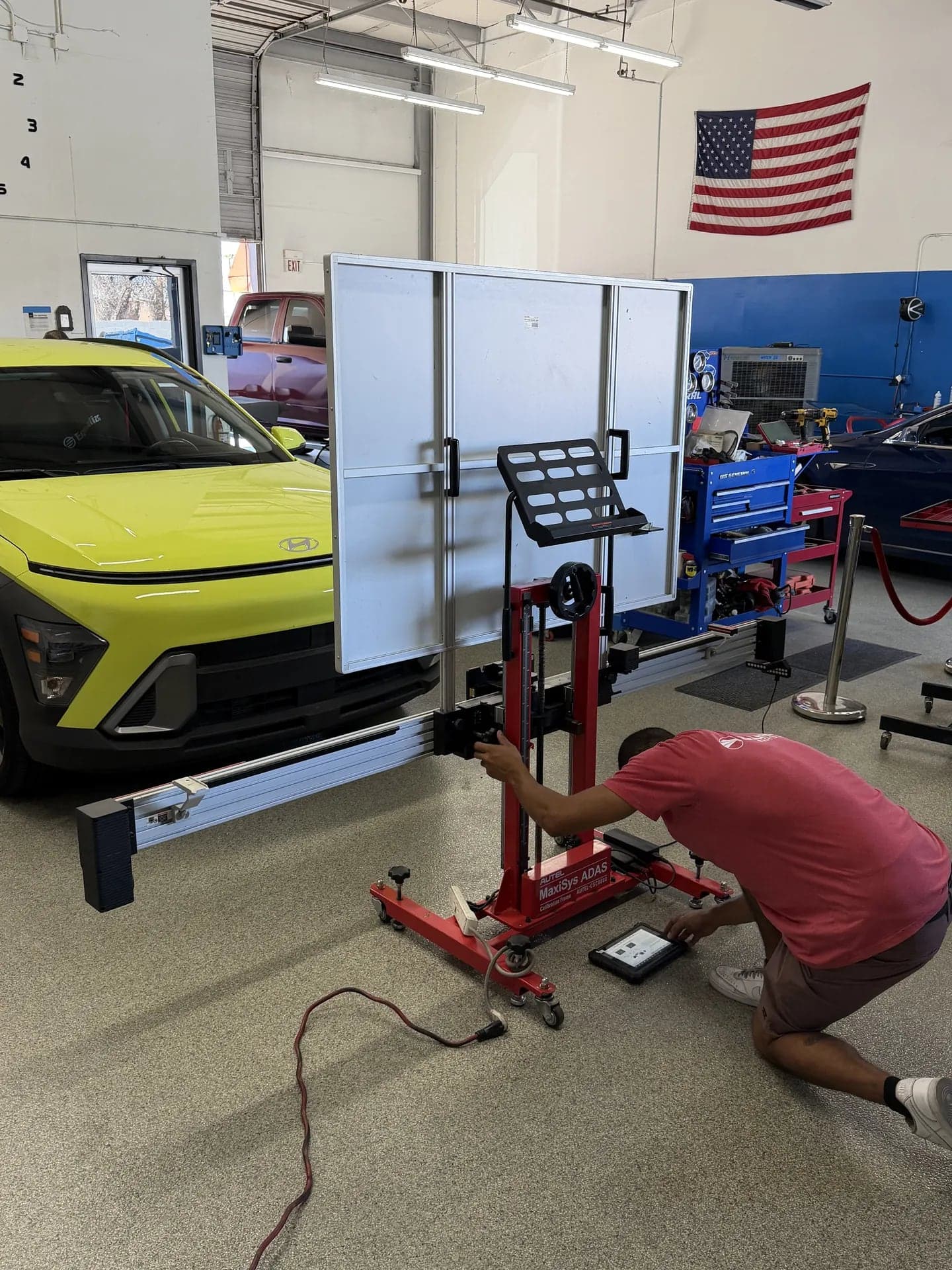 Technician adjusting the Autel calibration frame in front of a Hyundai Kona