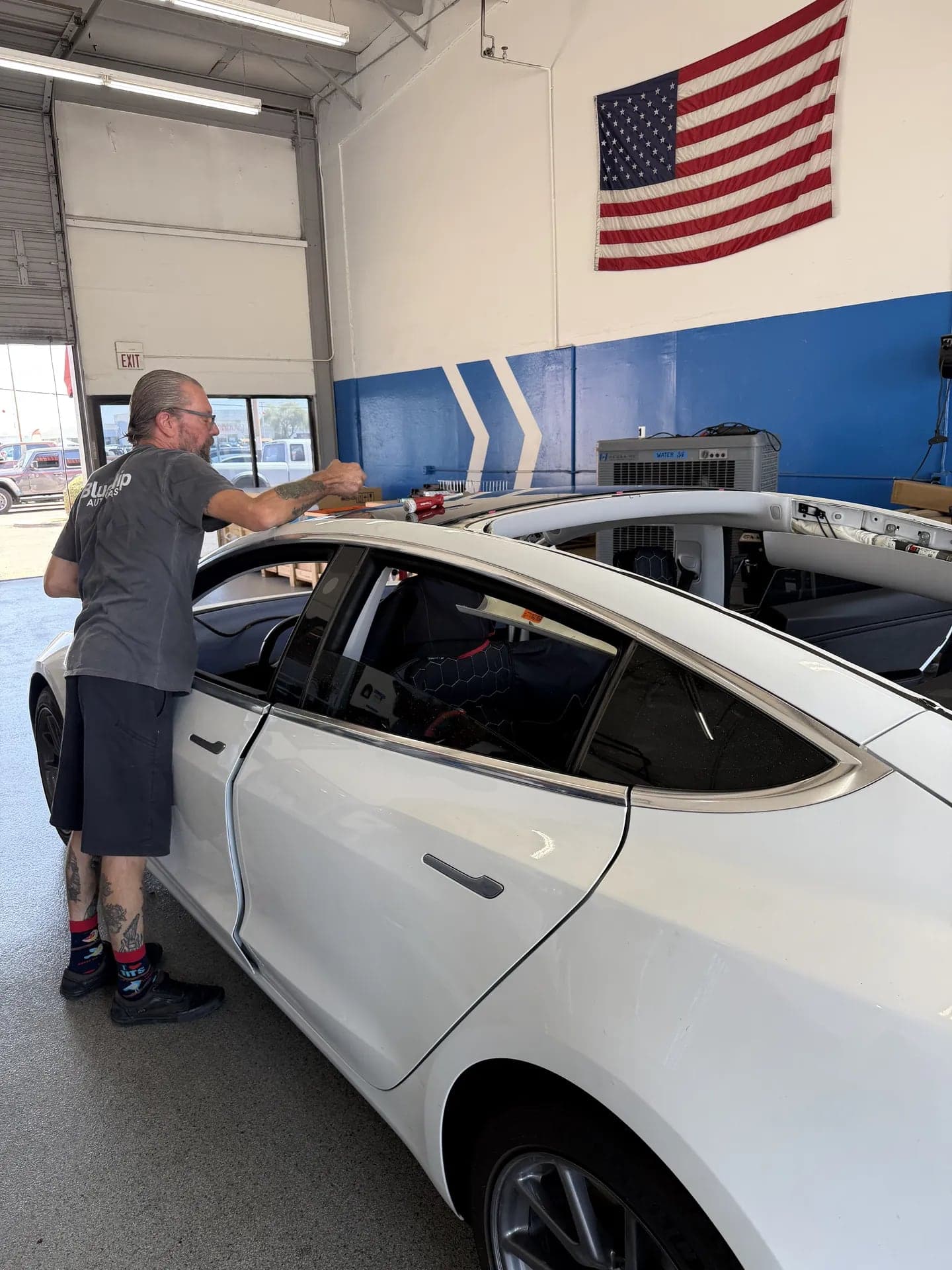 Tesla with its glass roof removed during a roof glass replacement at Blue Chip Auto Glass