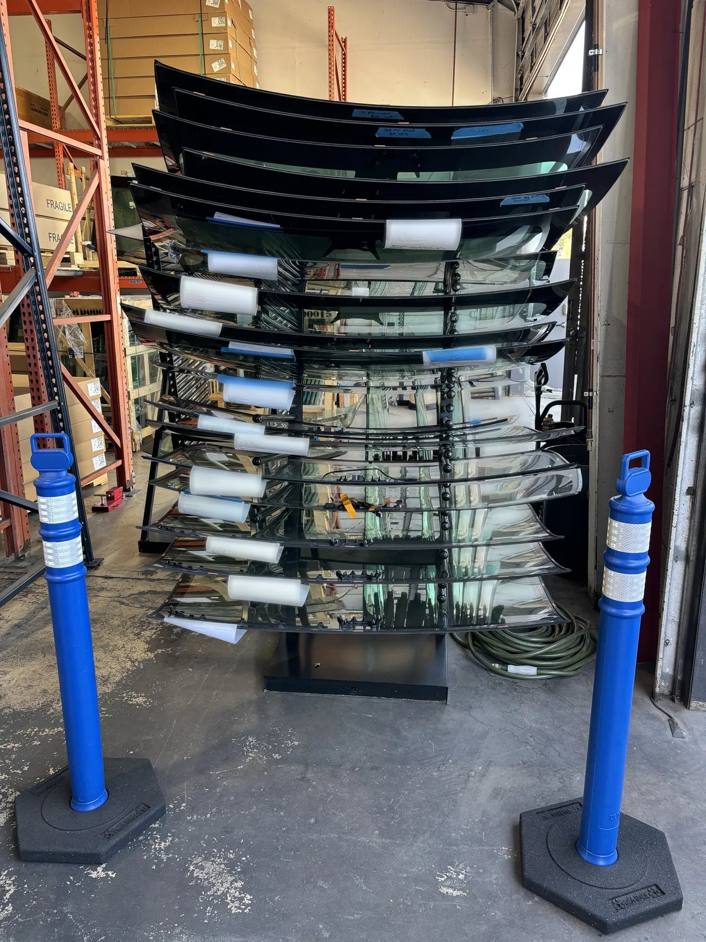 Rack of pre-tinted replacement windshields ready for installation in the Blue Chip shop