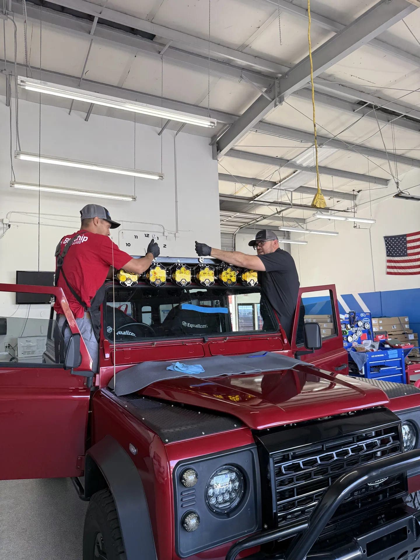 Two Blue Chip technicians setting a new windshield with suction cups