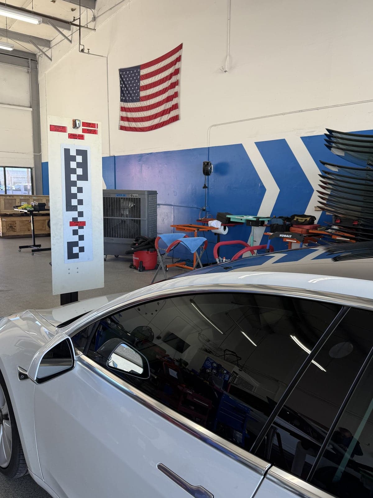 Calibration target set up in front of a white Tesla Model 3 at the specified height