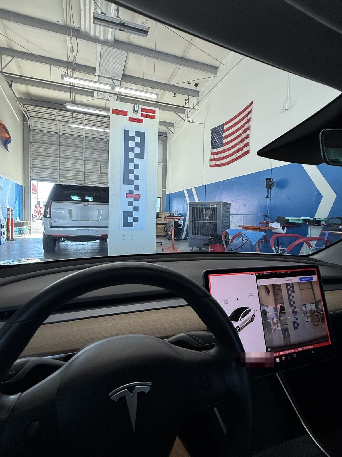 Driver seat view of the calibration target through the new windshield, with the camera view on the touchscreen