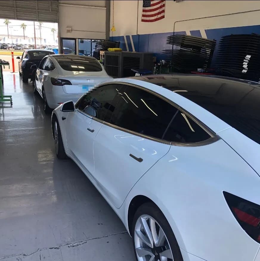 Three Tesla Model 3s lined up inside the Blue Chip Auto Glass shop