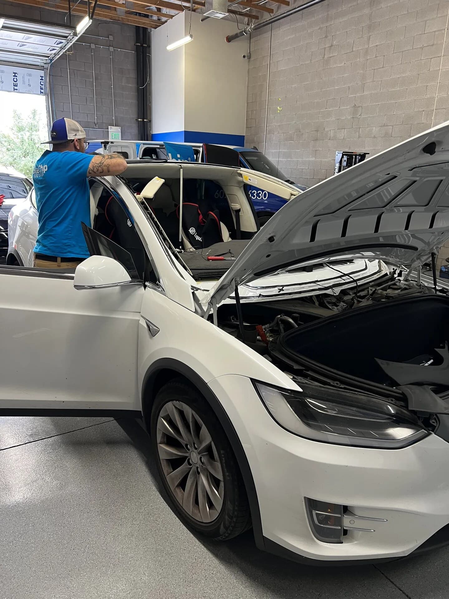 Blue Chip technician preparing the Tesla Model X windshield opening