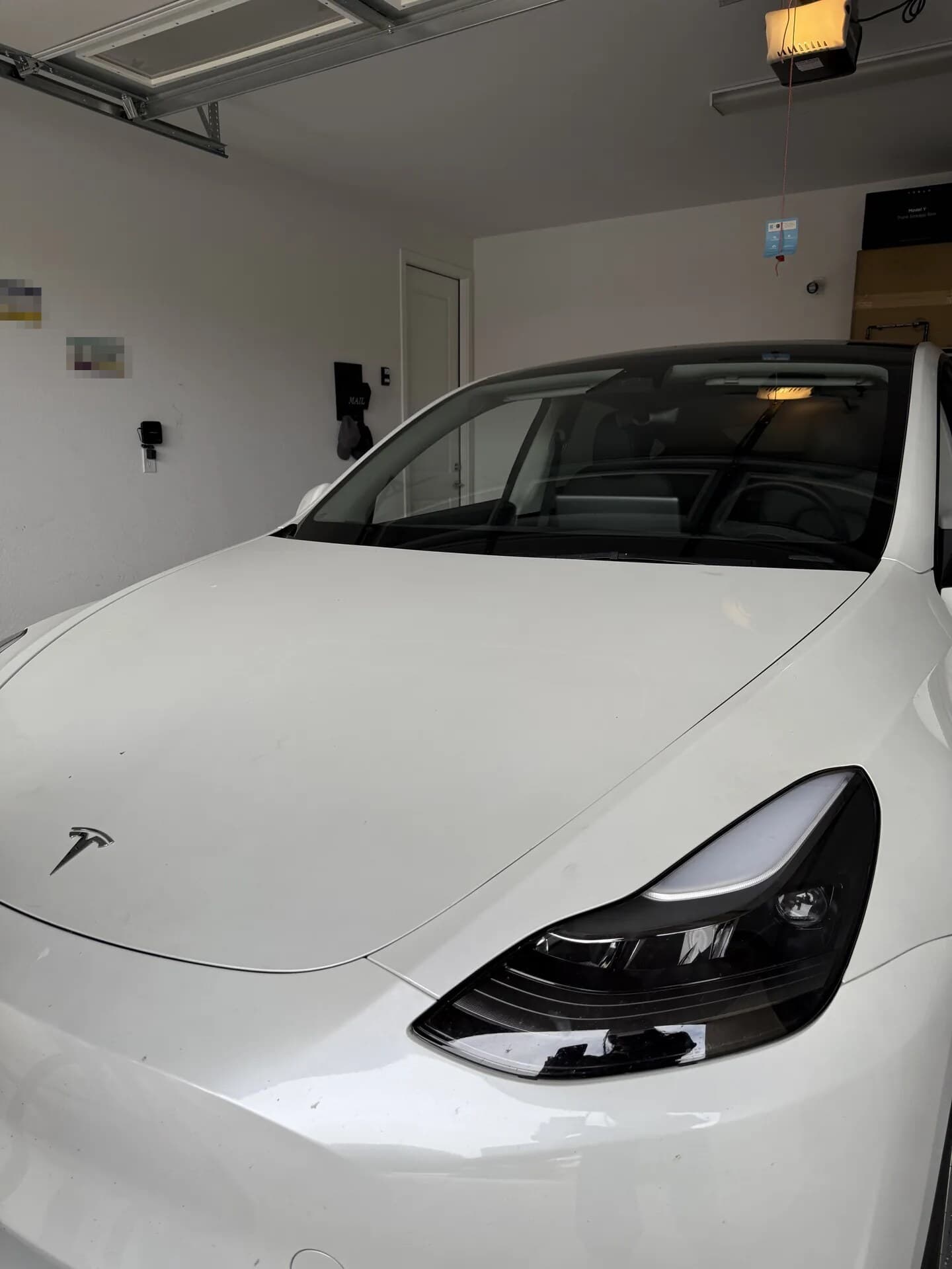 Close-up of the new windshield on a white Tesla Model Y in a home garage
