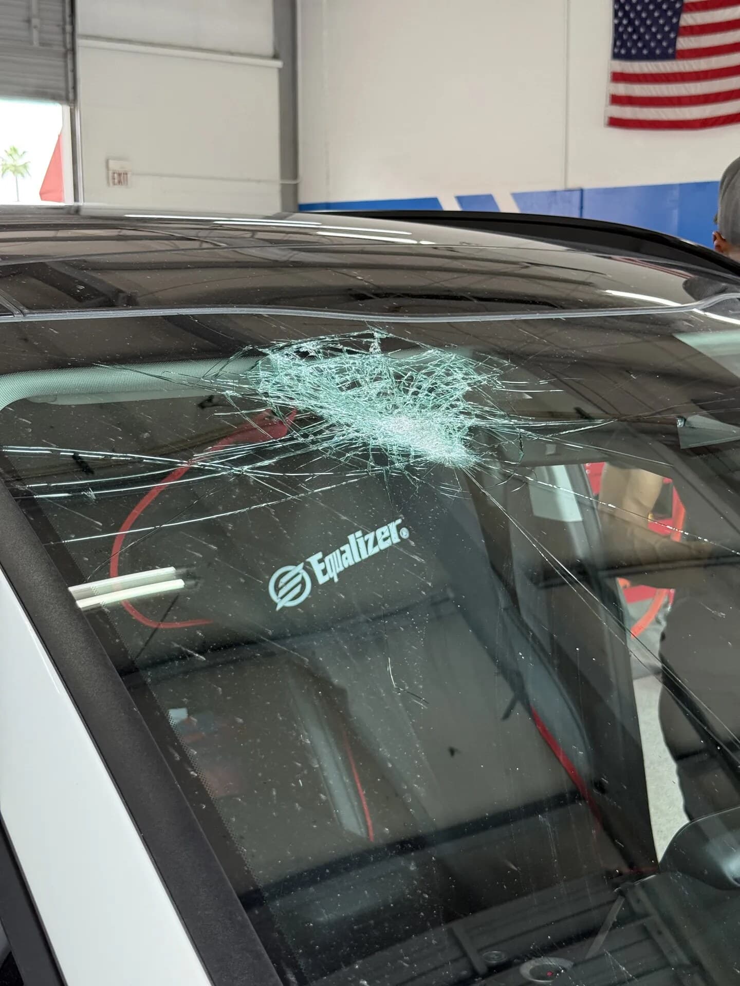 Tesla windshield with a large impact break and cracks spreading across the glass