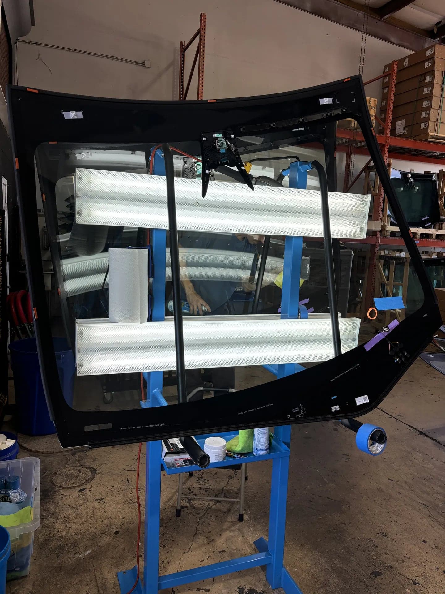 New Tesla windshield being cleaned and inspected on the inspection stand
