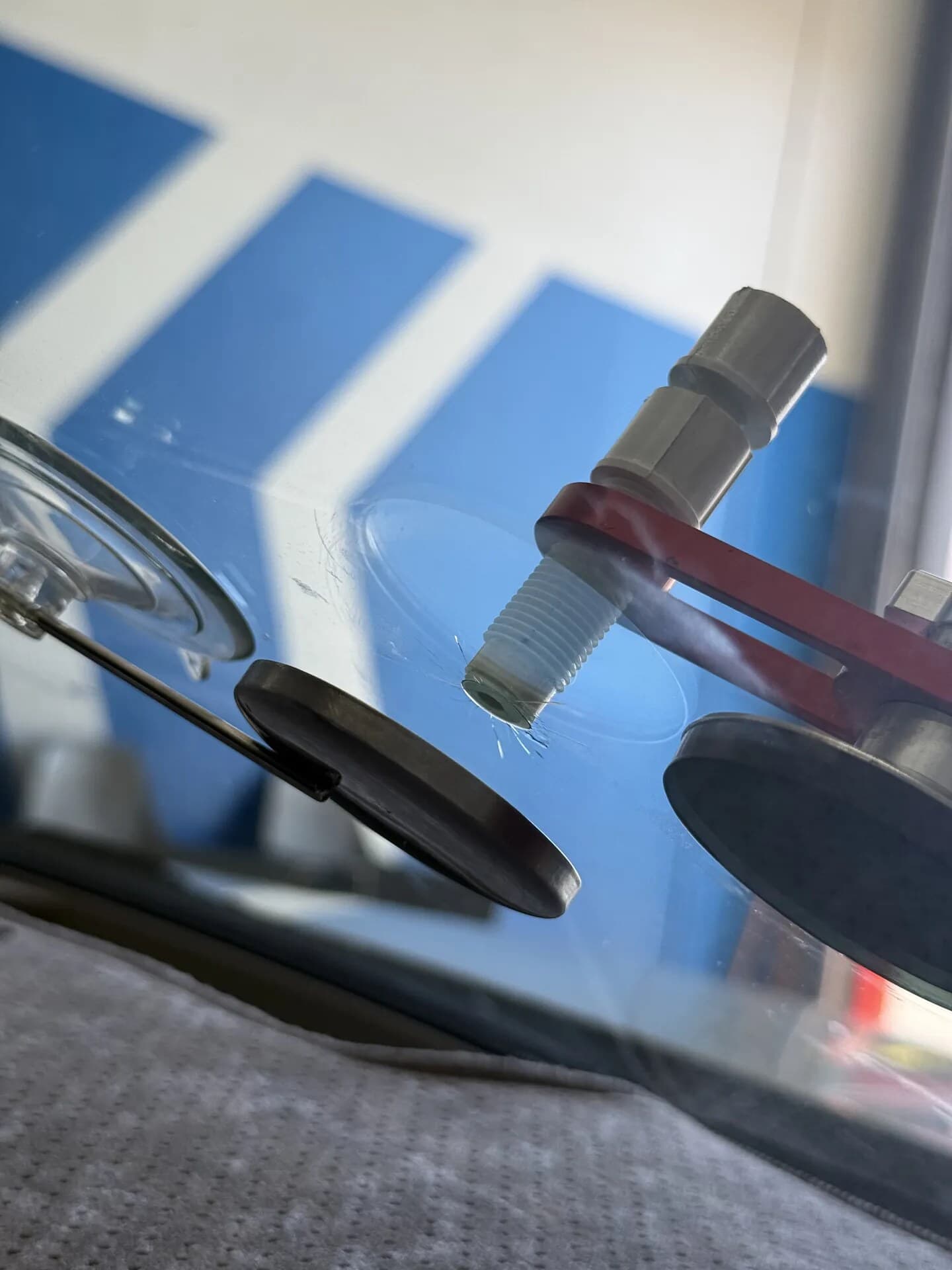 Windshield chip repair bridge mounted on the glass with suction cups in the Blue Chip shop