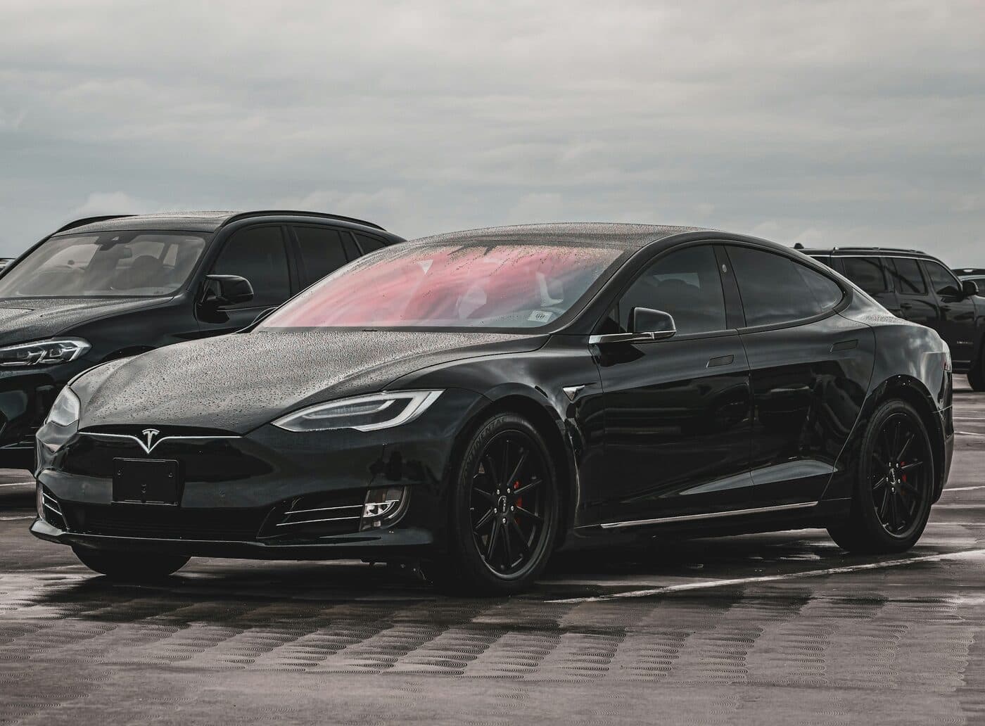 Black Tesla Model S parked in a lot on a cloudy day