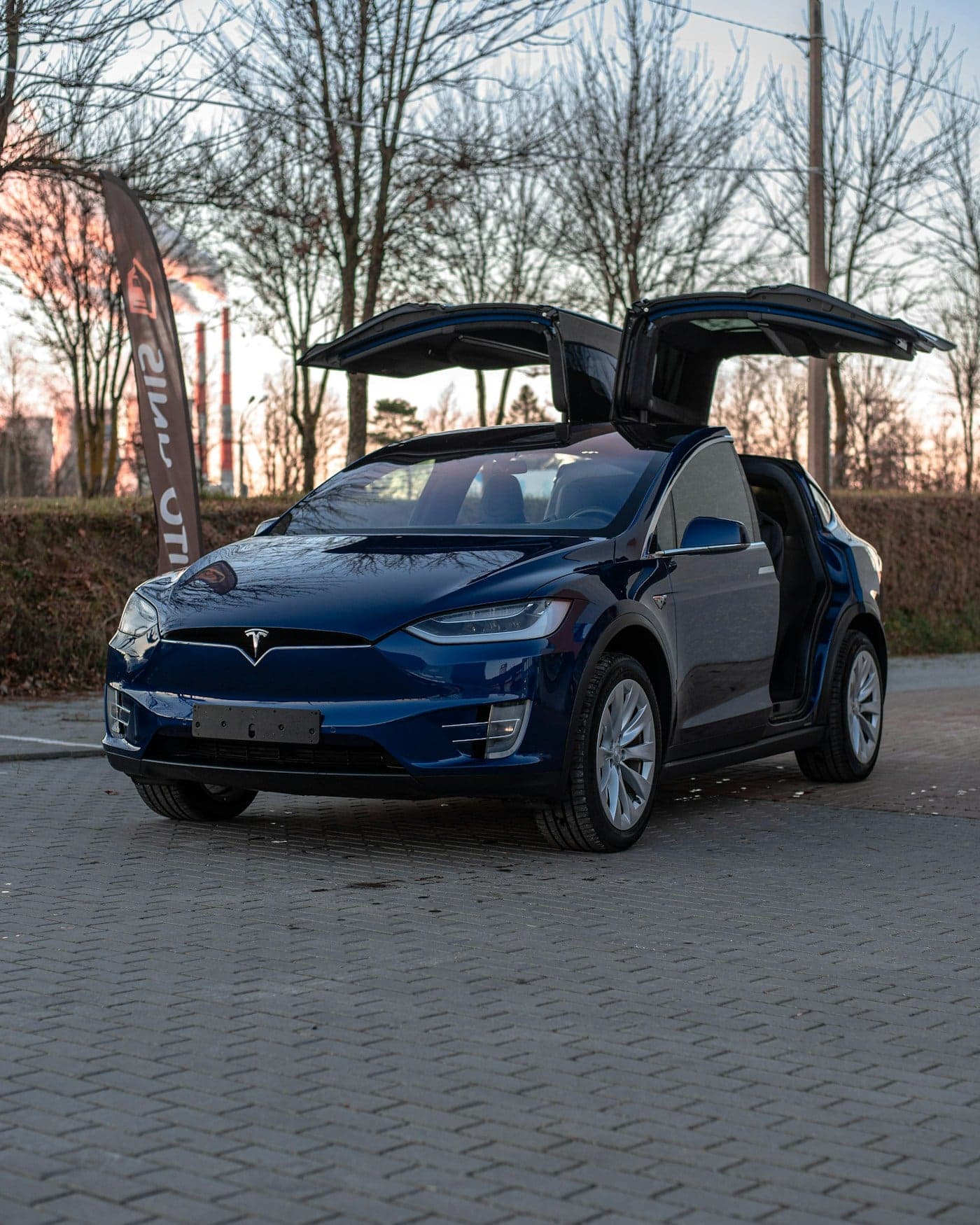 Blue Tesla Model X with its Falcon Wing doors open