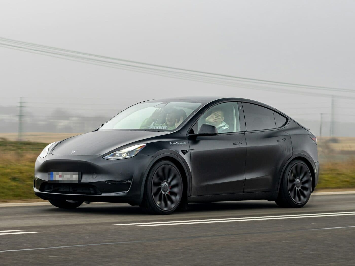 Gray Tesla Model Y driving on an open road